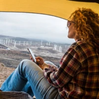 Woman in camping tent looking outside